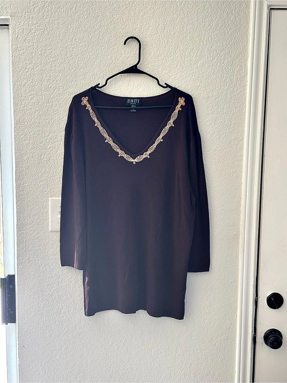 This is a dark brown Finity long-sleeve top featuring an intricate beaded V-neck